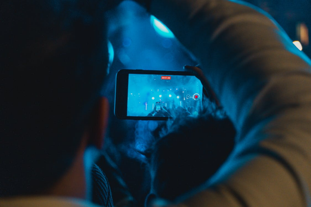 Person recording a live event on a phone, illustrating viral search spikes.